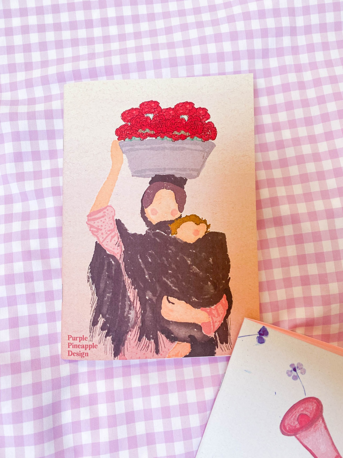 Postal ilustrado com mulher, criança e flores sobre fundo xadrez lilás e branco