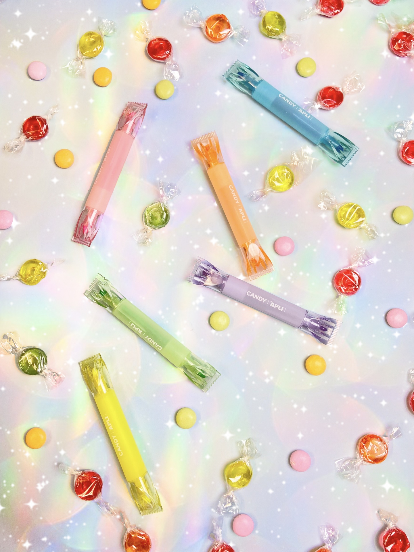 Balas coloridas e rebuçados em embalagem pastel sobre fundo brilhante