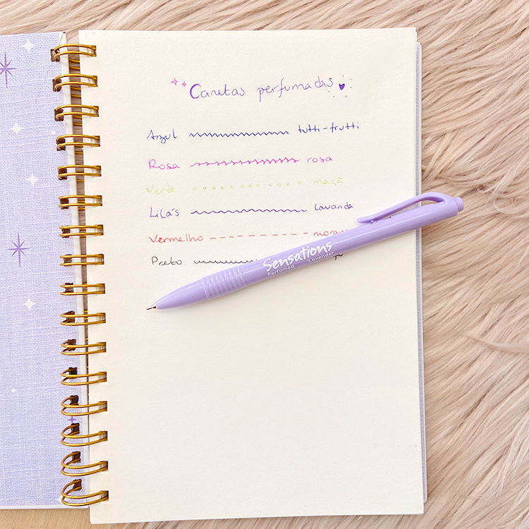 Caderno com escrita colorida e caneta roxa Sensations sobre superfície felpuda
