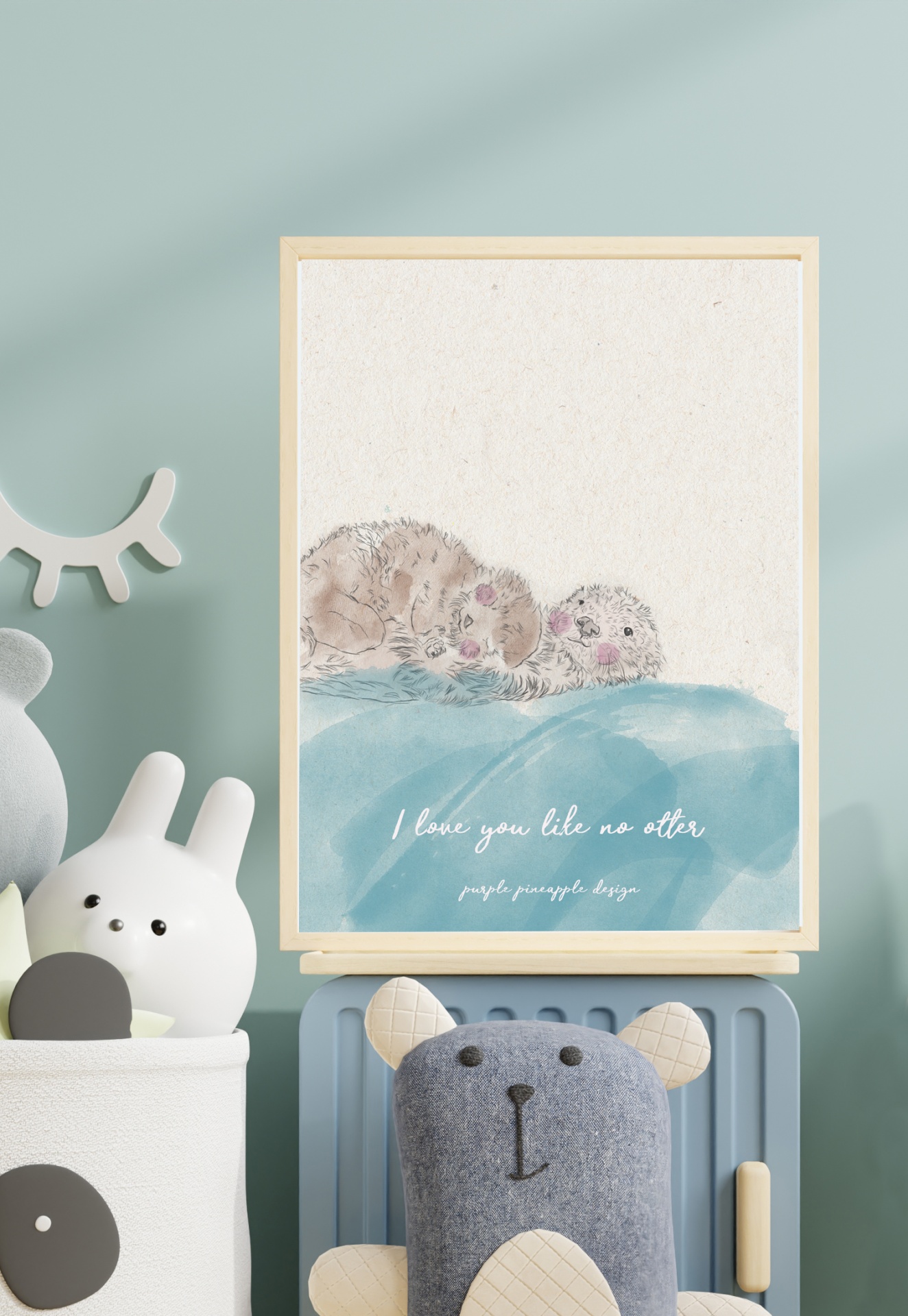 quadro decorativo com desenho de coelhos a dormir e texto, em parede azul clara com brinquedos por perto