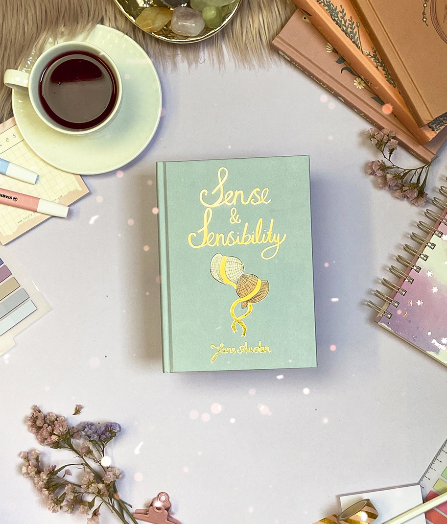 Livro Sense & Sensibility com chá e materiais de papelaria numa mesa