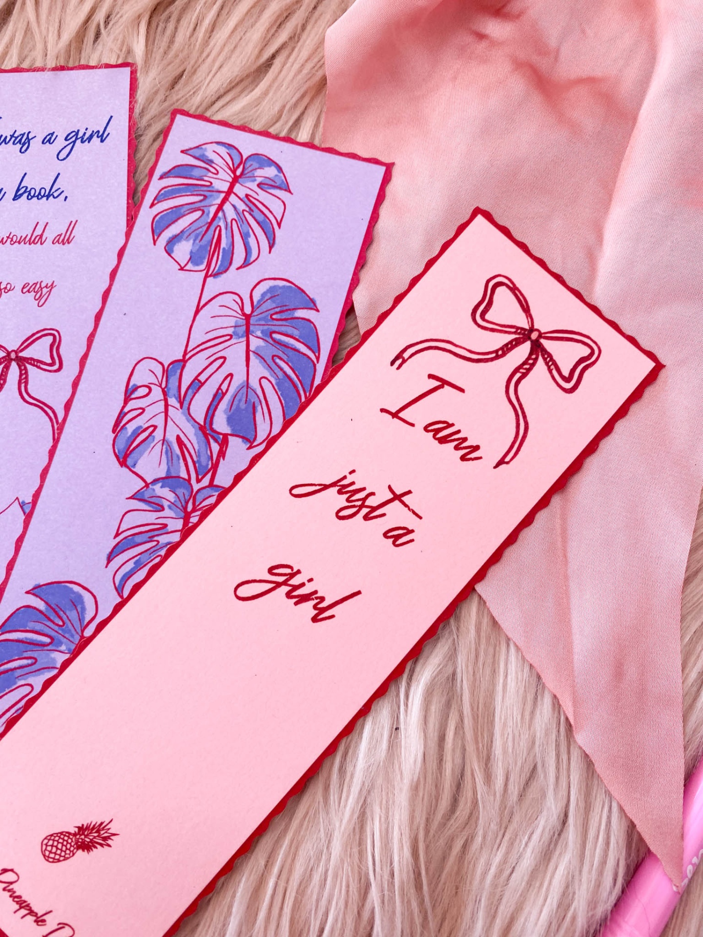 Marcadores de página rosa com texto e ilustração sobre fundo rosa de pelo e tecido