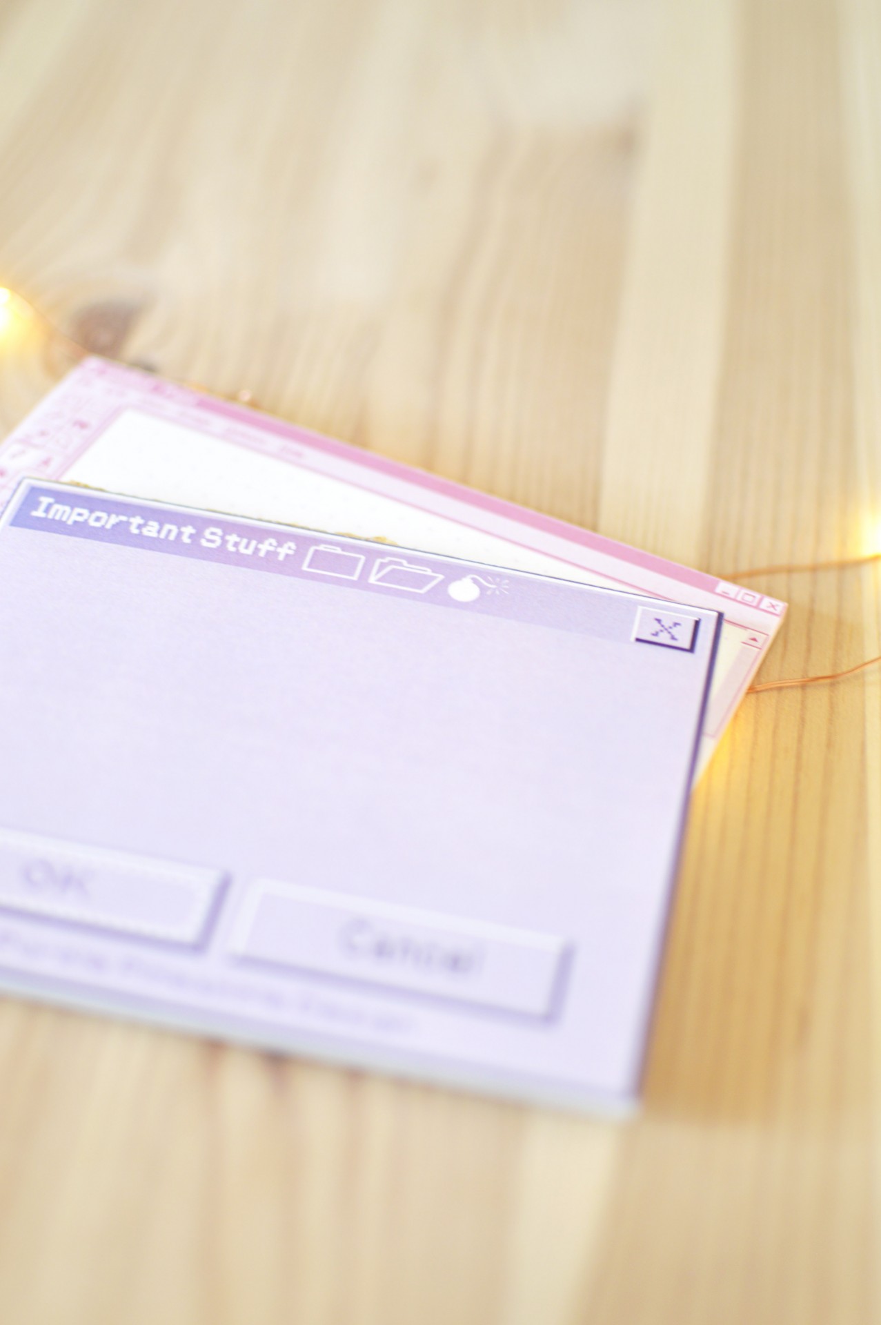 Bloco de notas com design de janela de computador em lilás claro sobre madeira