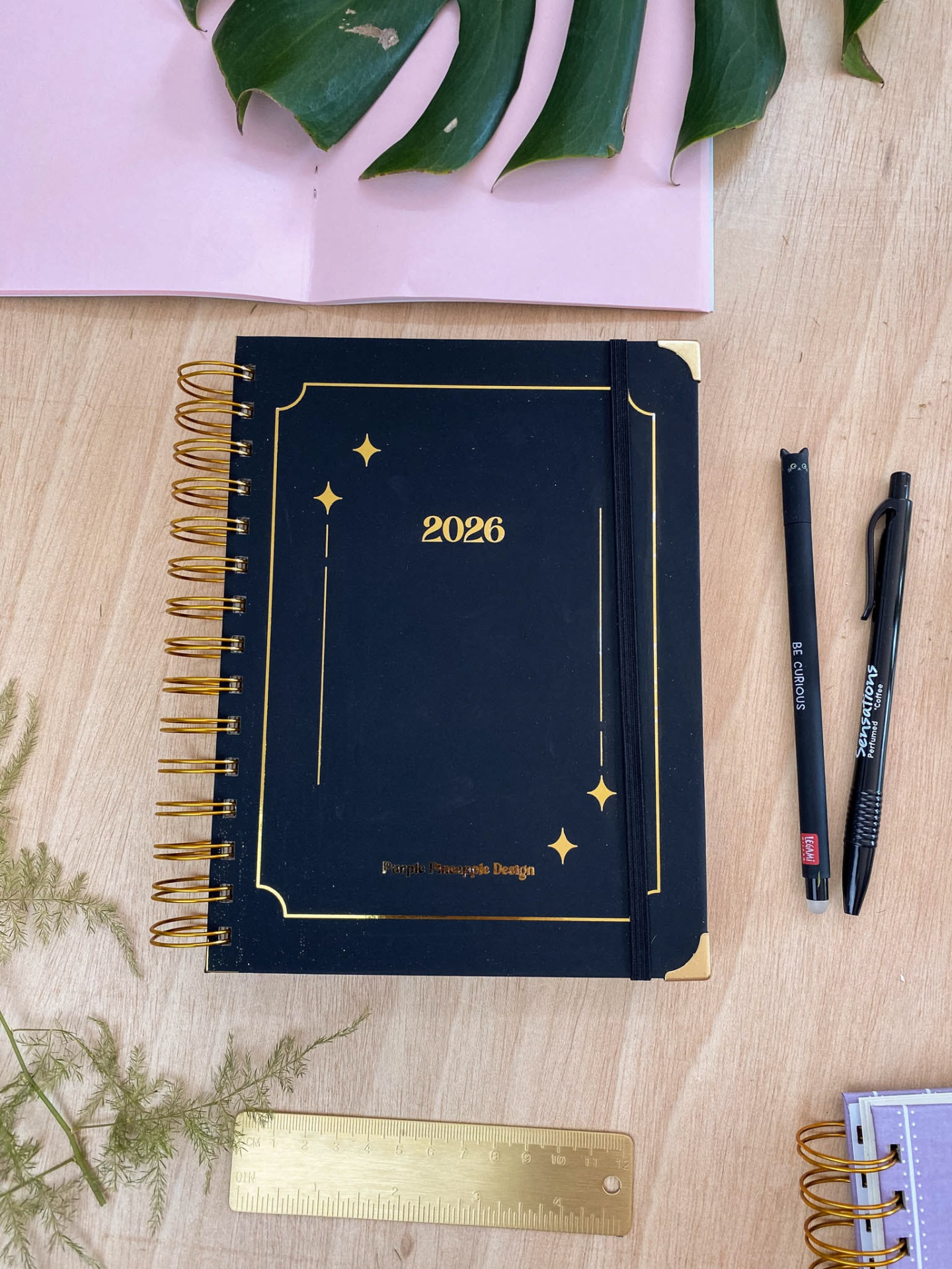 agenda espiral preta com detalhes dourados e elástico