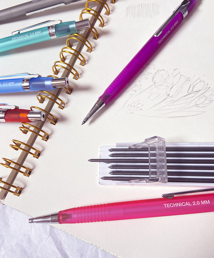 Canetas técnicas coloridas e estojo de recargas sobre caderno espiral de desenho