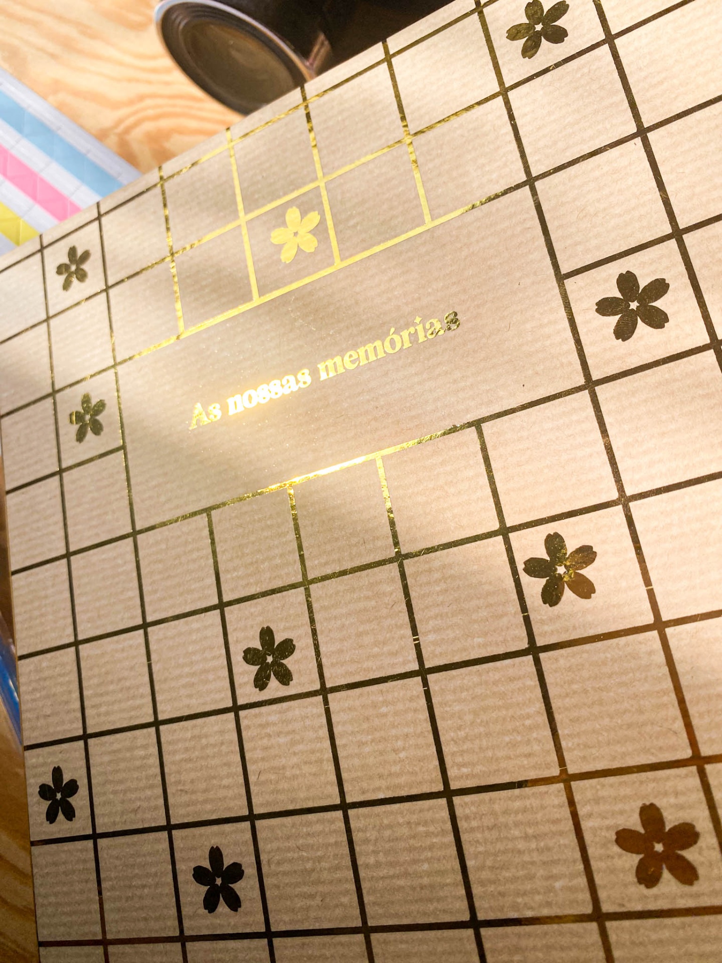 Álbum com capa dourada e padrão de flores