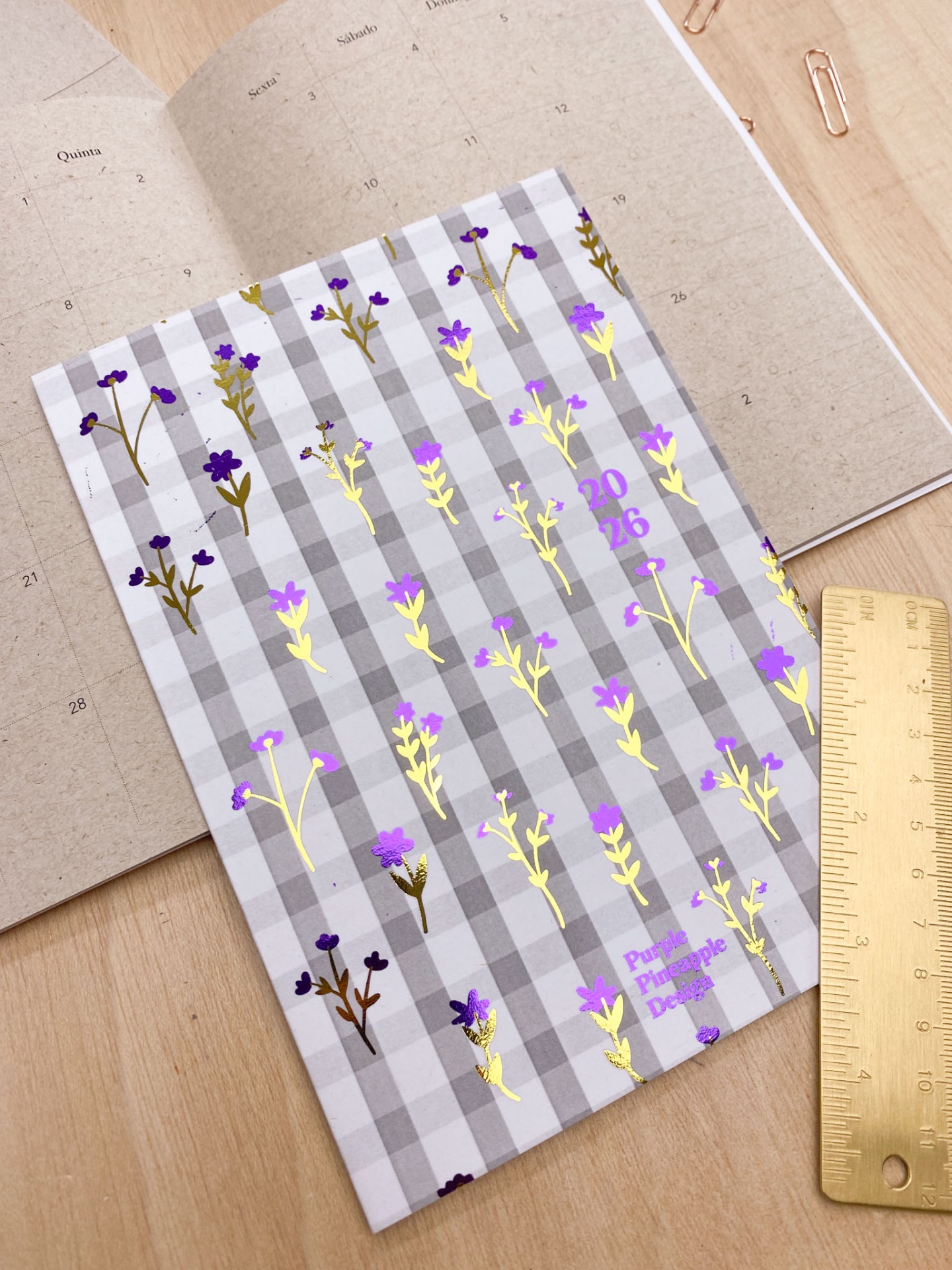Agenda 2026 com capa floral cinza e mesa de madeira