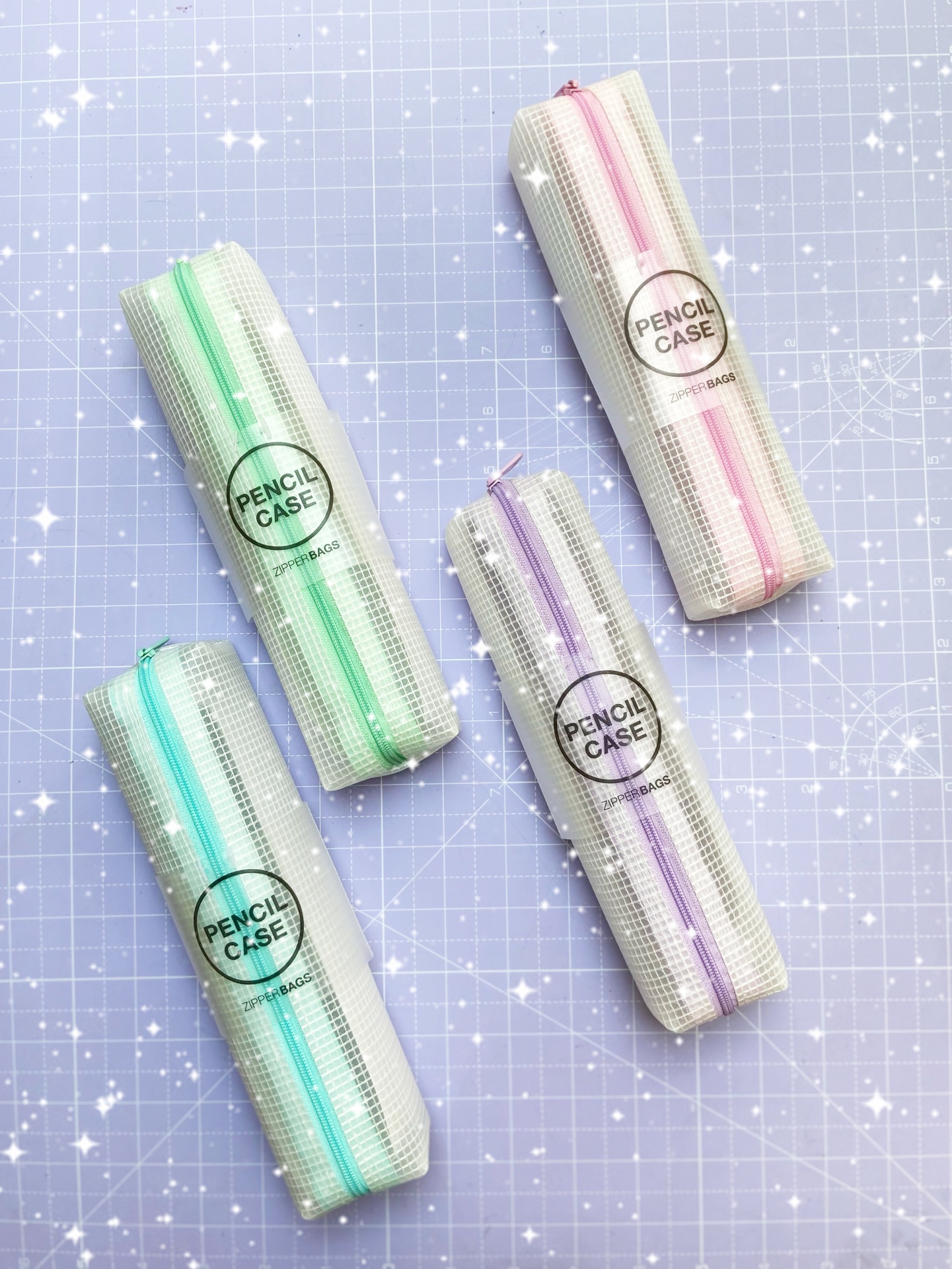 Estojos para lápis brancos com padrão quadriculado e fechos coloridos sobre fundo azul quadriculado.