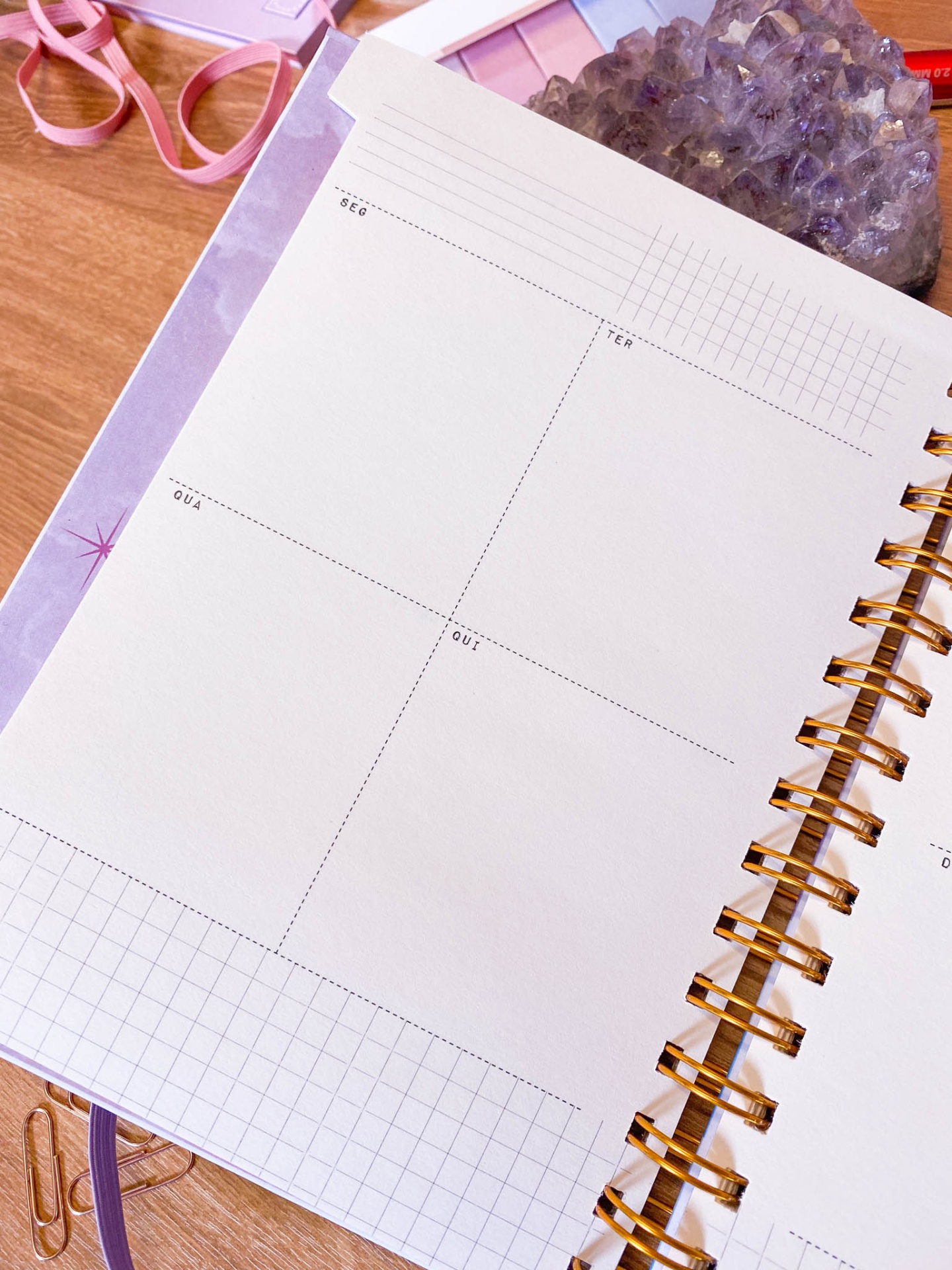 Caderno aberto com páginas divididas em quadrantes e espiral dourada