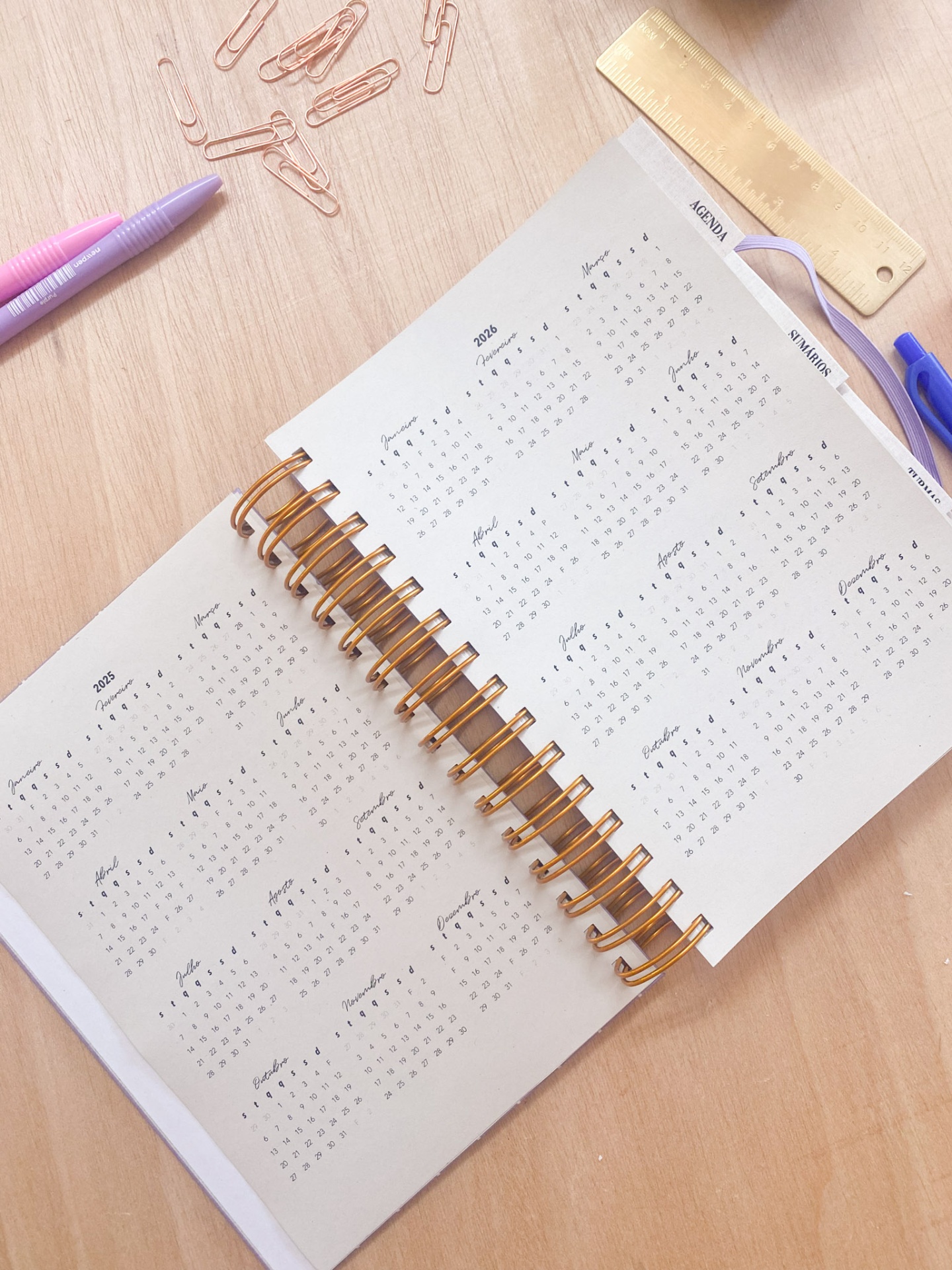 Agenda espiral aberta com calendário 2024 e objetos de escritório