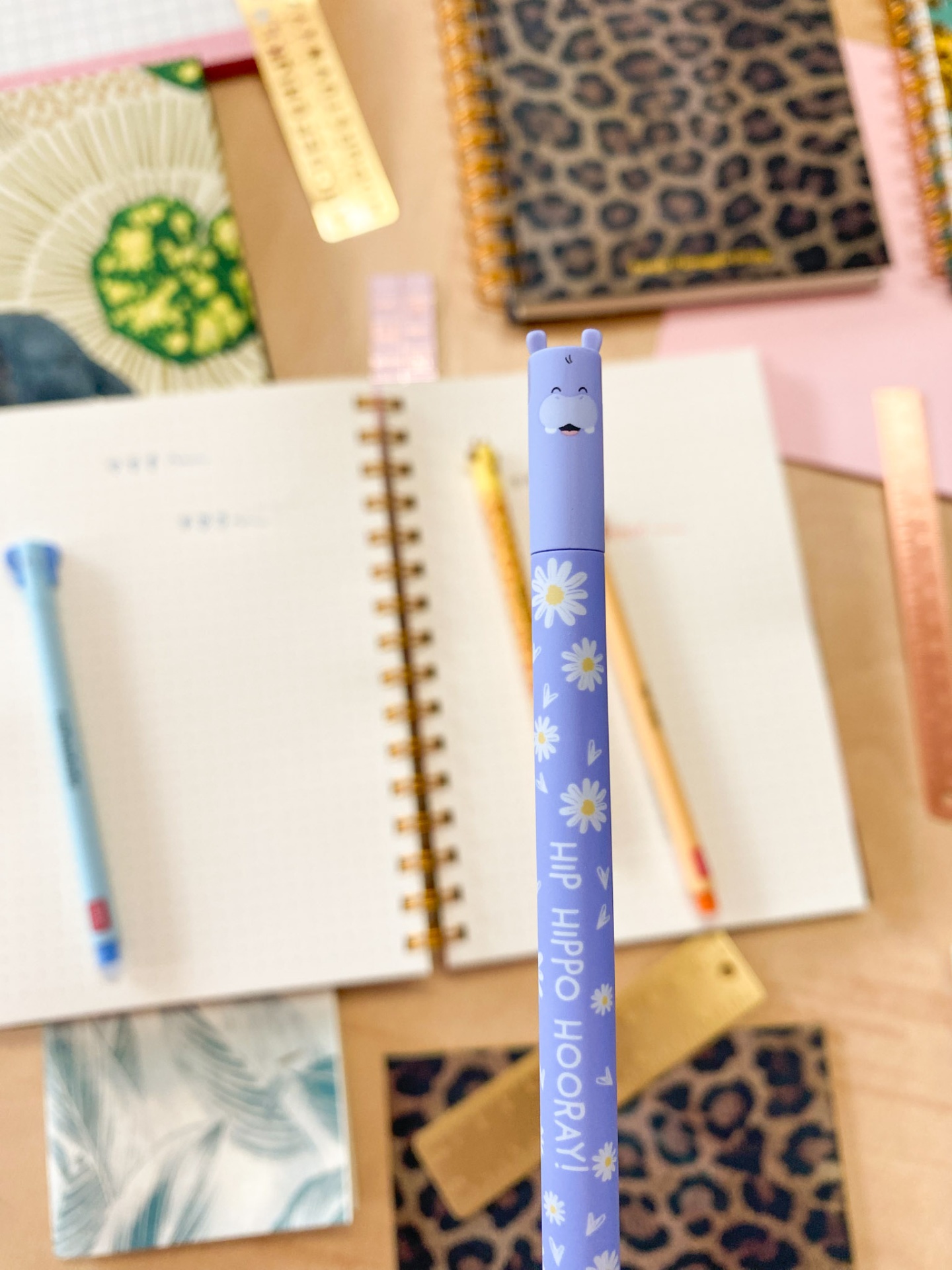 Lápis azul decorado com flores e texto HIP HIPPO HOORAY com tampa em forma de cabeça de hipopótamo