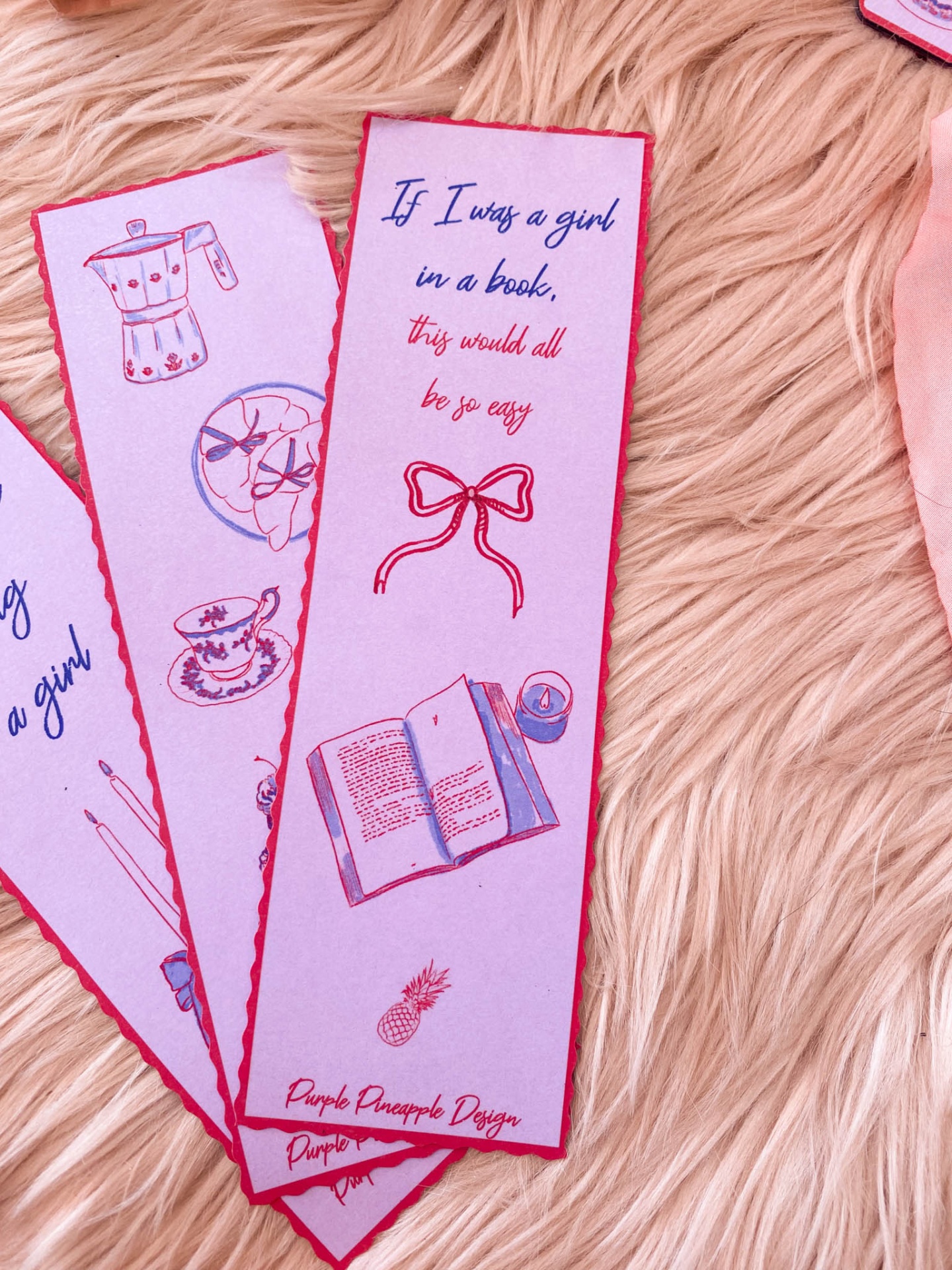 Marcadores de livro com desenhos e texto em inglês sobre tecido peludo creme.