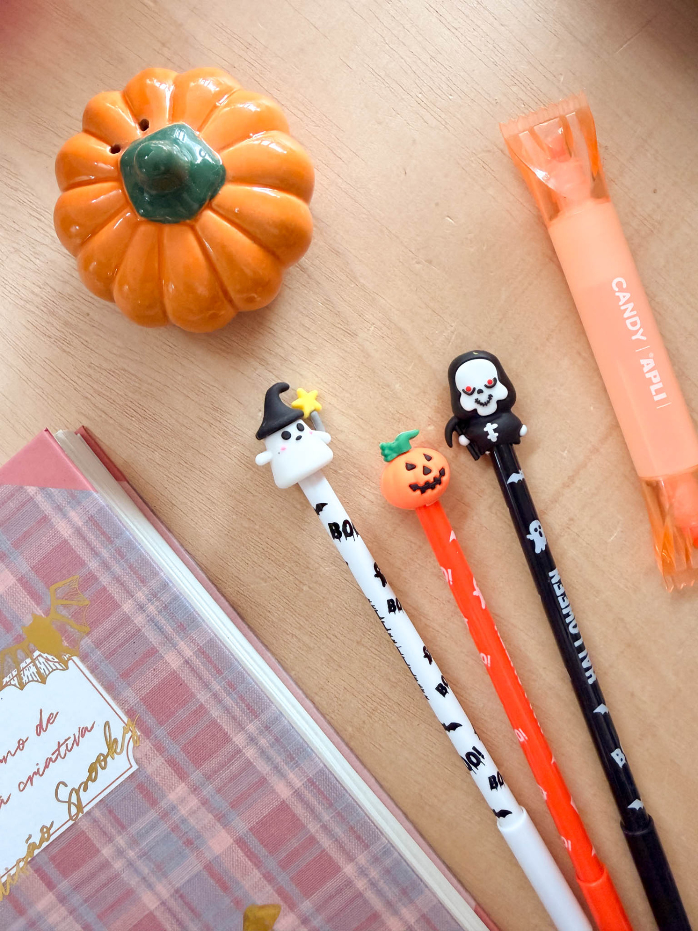 Produtos de escritório com tema de Halloween sobre uma mesa de madeira clara.