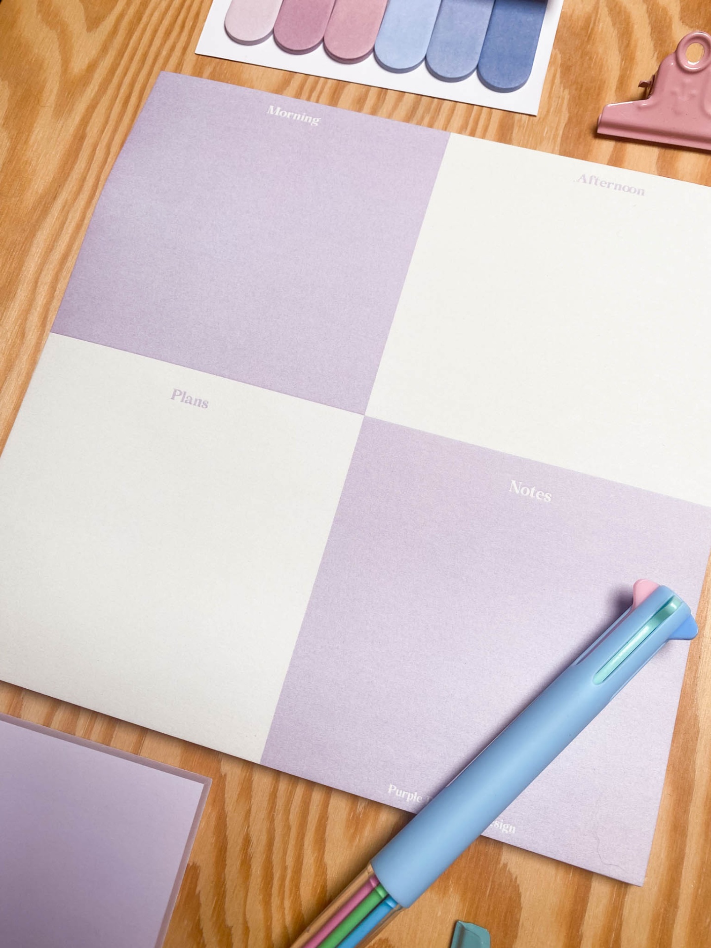 Bloco de notas com seções Morning, Afternoon, Plans, Notes, brinquedo de plástico azul e paleta de cores pasteis