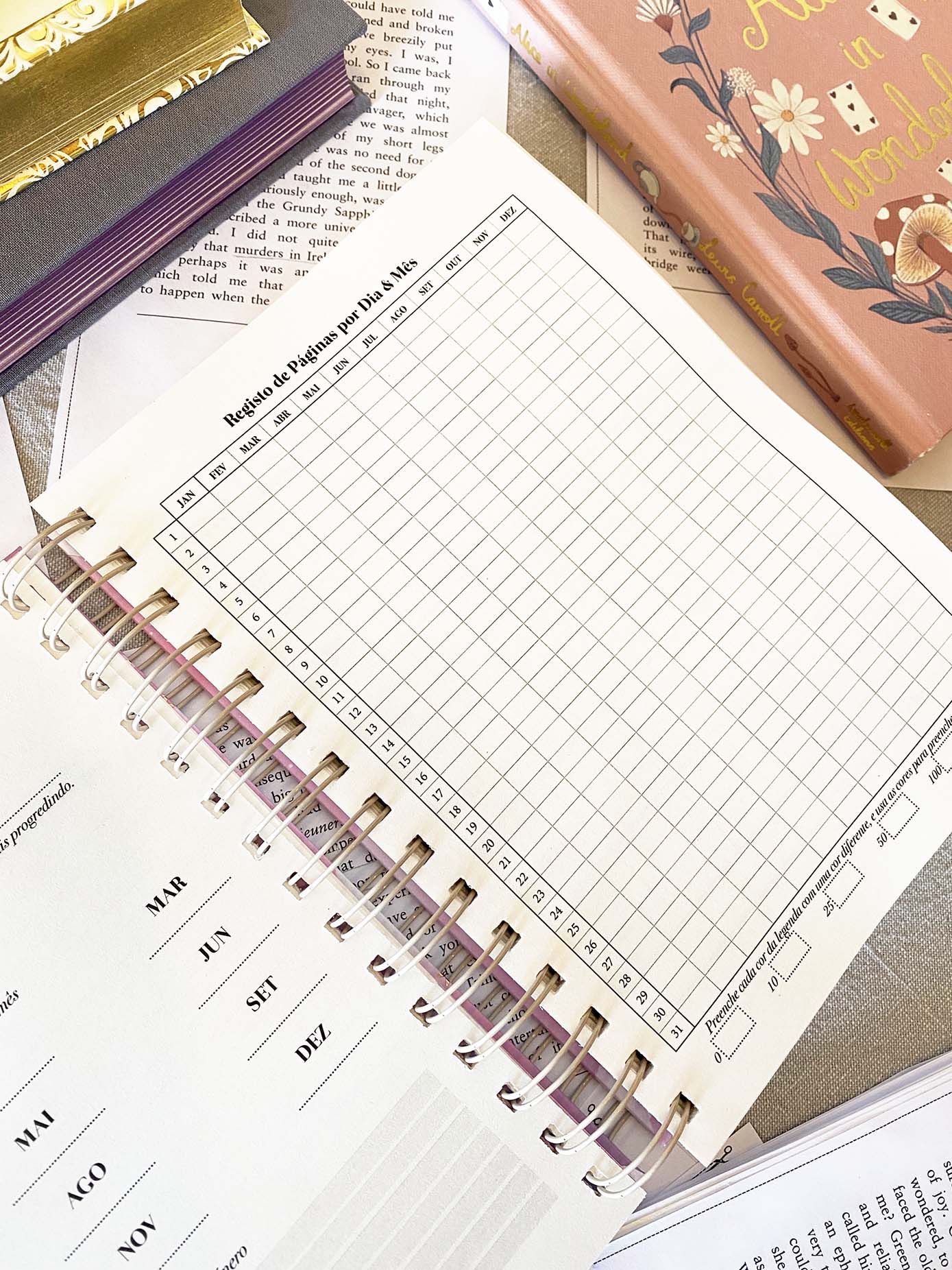 Agenda rosa com ilustração e páginas abertas com tabela de registo de páginas