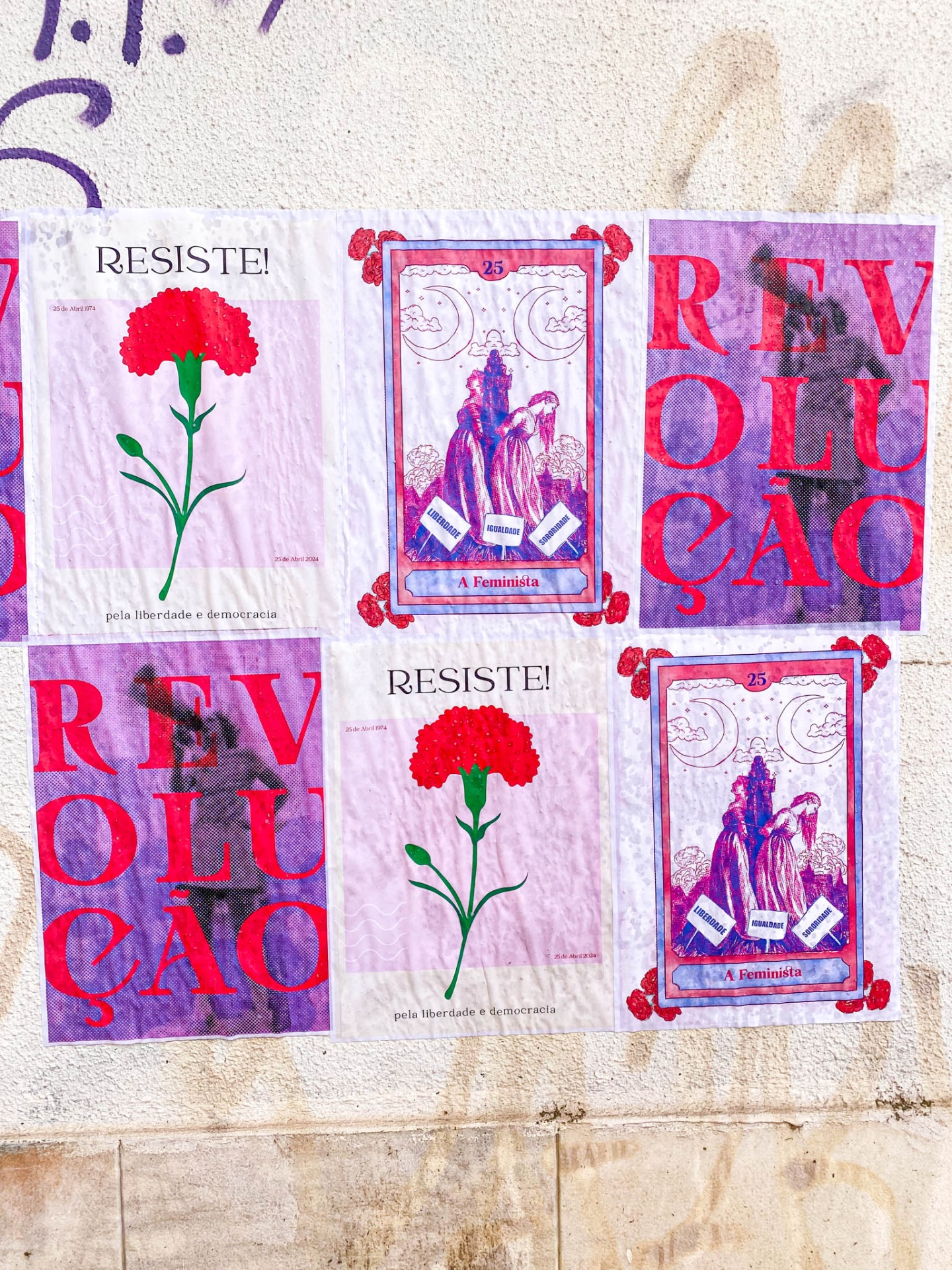 Cartazes colados numa parede com cravos vermelhos, texto RESISTE! e REVOLUÇÃO e ilustrações feministas.