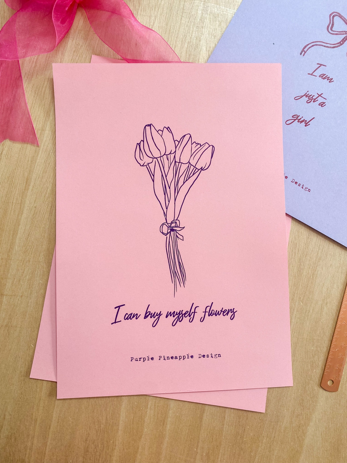 Cartazes coloridos com ilustrações e texto em inglês sobre uma mesa de madeira.