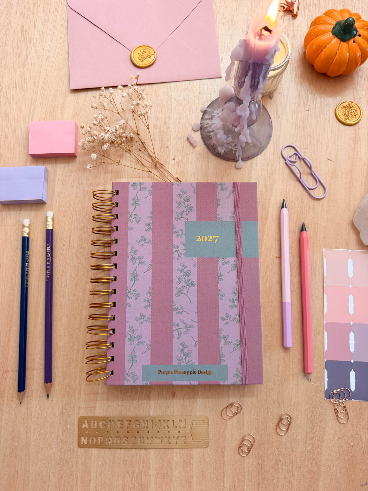 Agenda 2027 floral e riscada com material de escritório e decoração em mesa de madeira