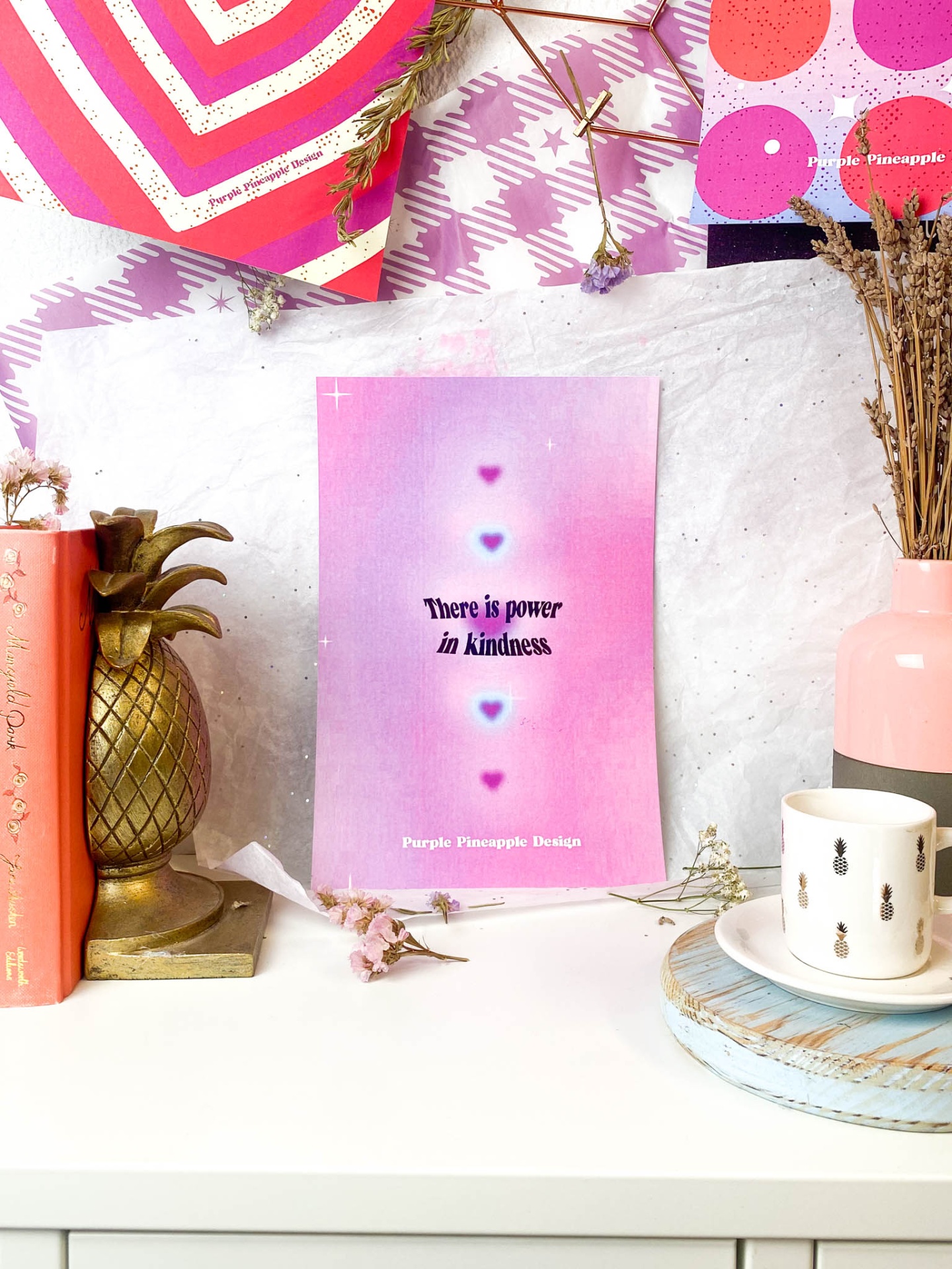 Cartaz motivacional rosa lilás com frase sobre bondade em ambiente decorativo