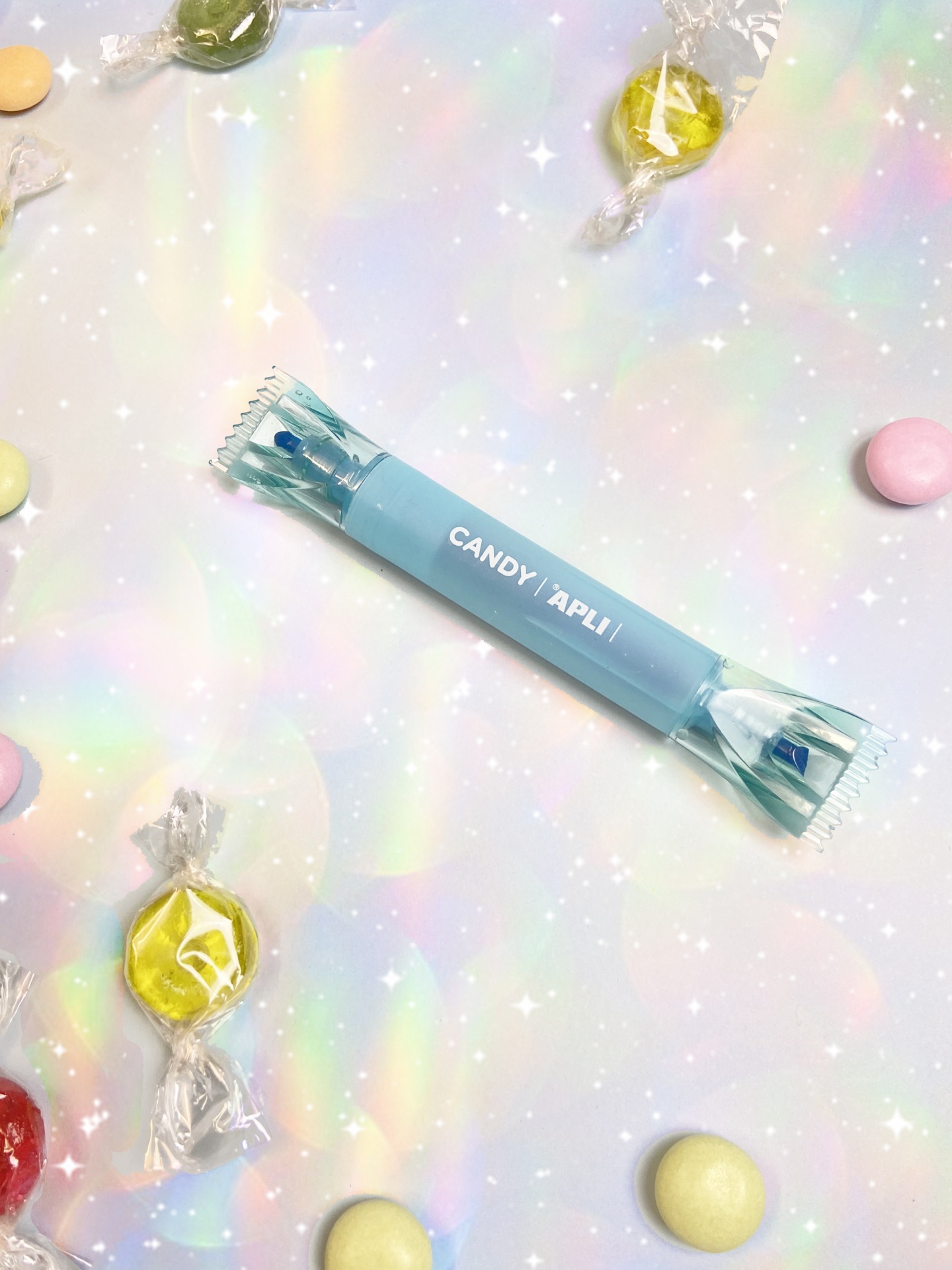 Doces embalados coloridos sobre fundo iridescente brilhante.