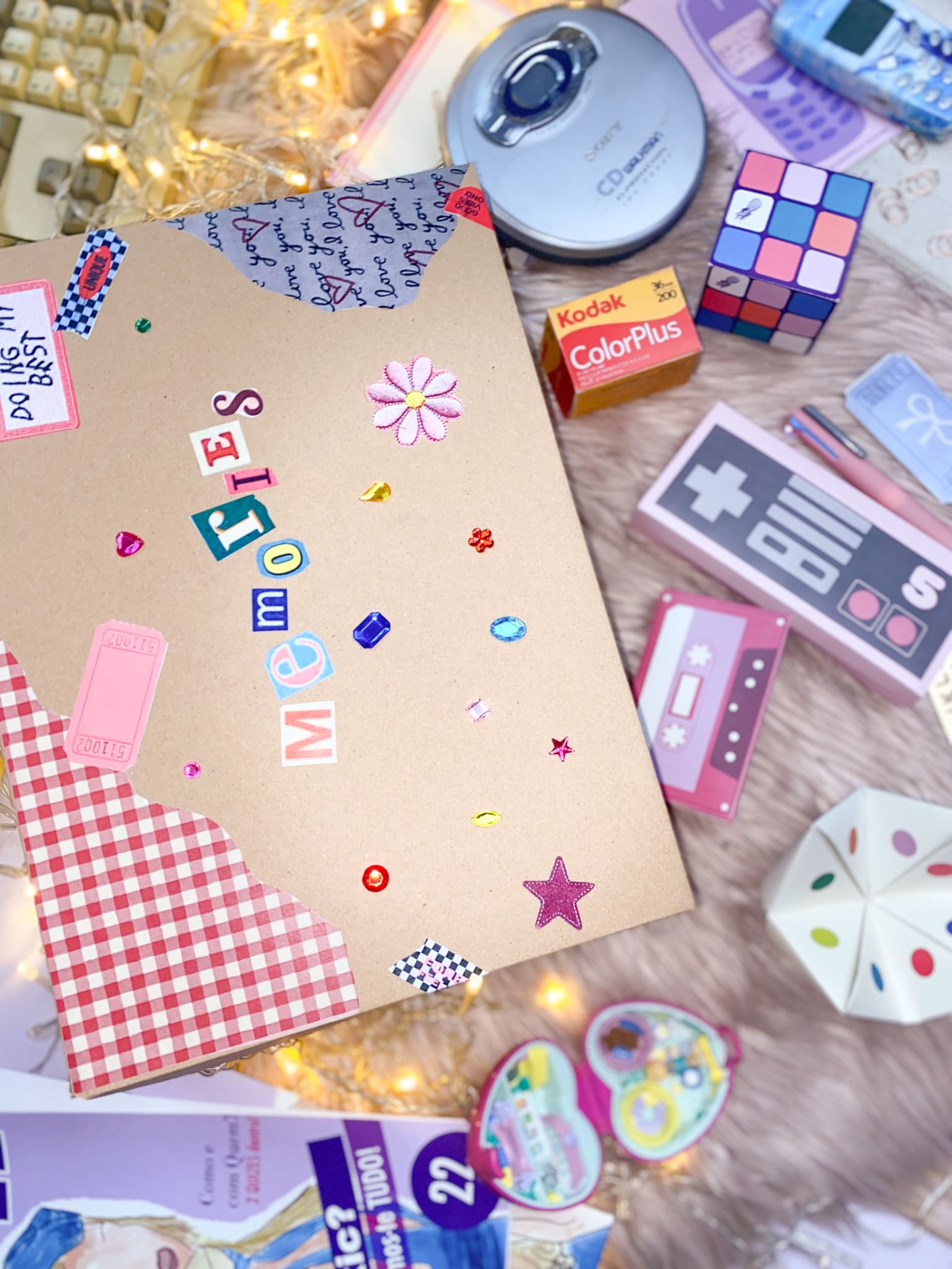 Caderno artesanal decorado com palavra 'Memories' e adesivos sobre superfície com objetos variados