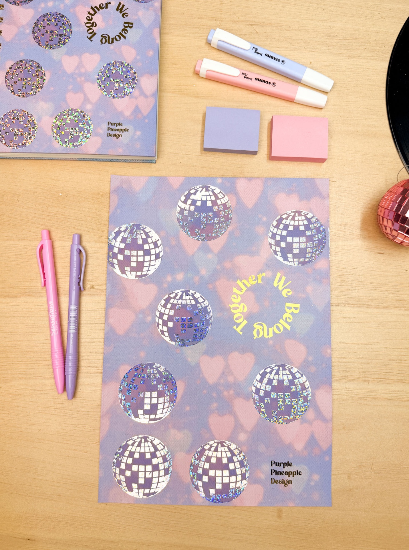 Material de escritório com decoração azul e rosa com acessórios coloridos sobre mesa de madeira