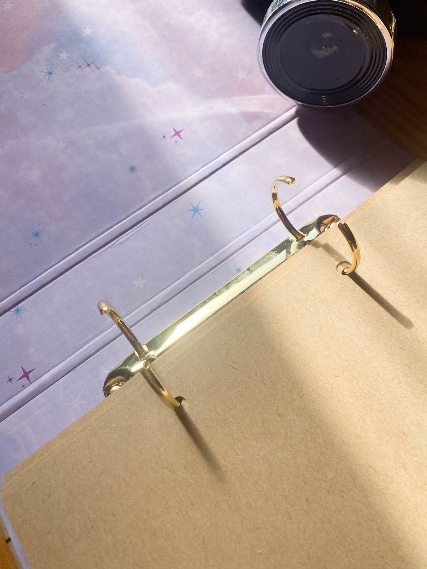 Caderno fichário com argolas douradas e capa com padrão de estrelas