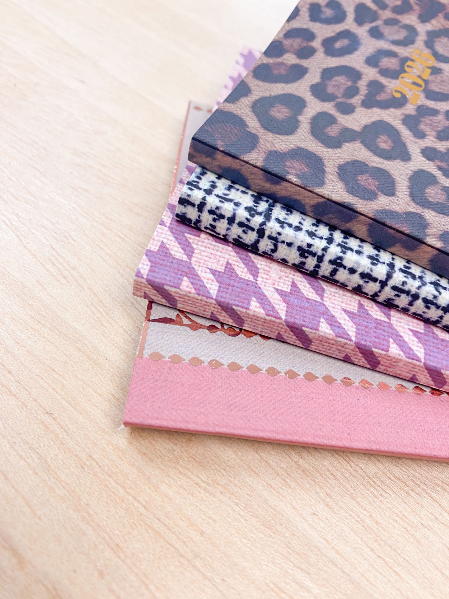 Blocos com capas texturizadas e padrões variados empilhados sobre uma superfície de madeira clara