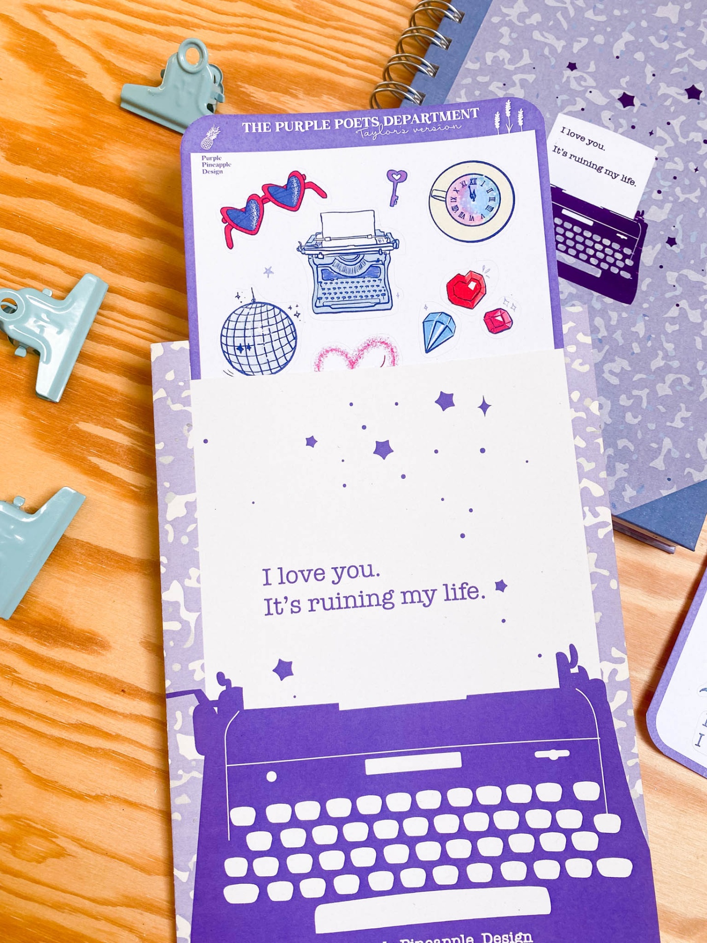 Cartão branco e roxo com texto e ilustrações sobre mesa de madeira clara