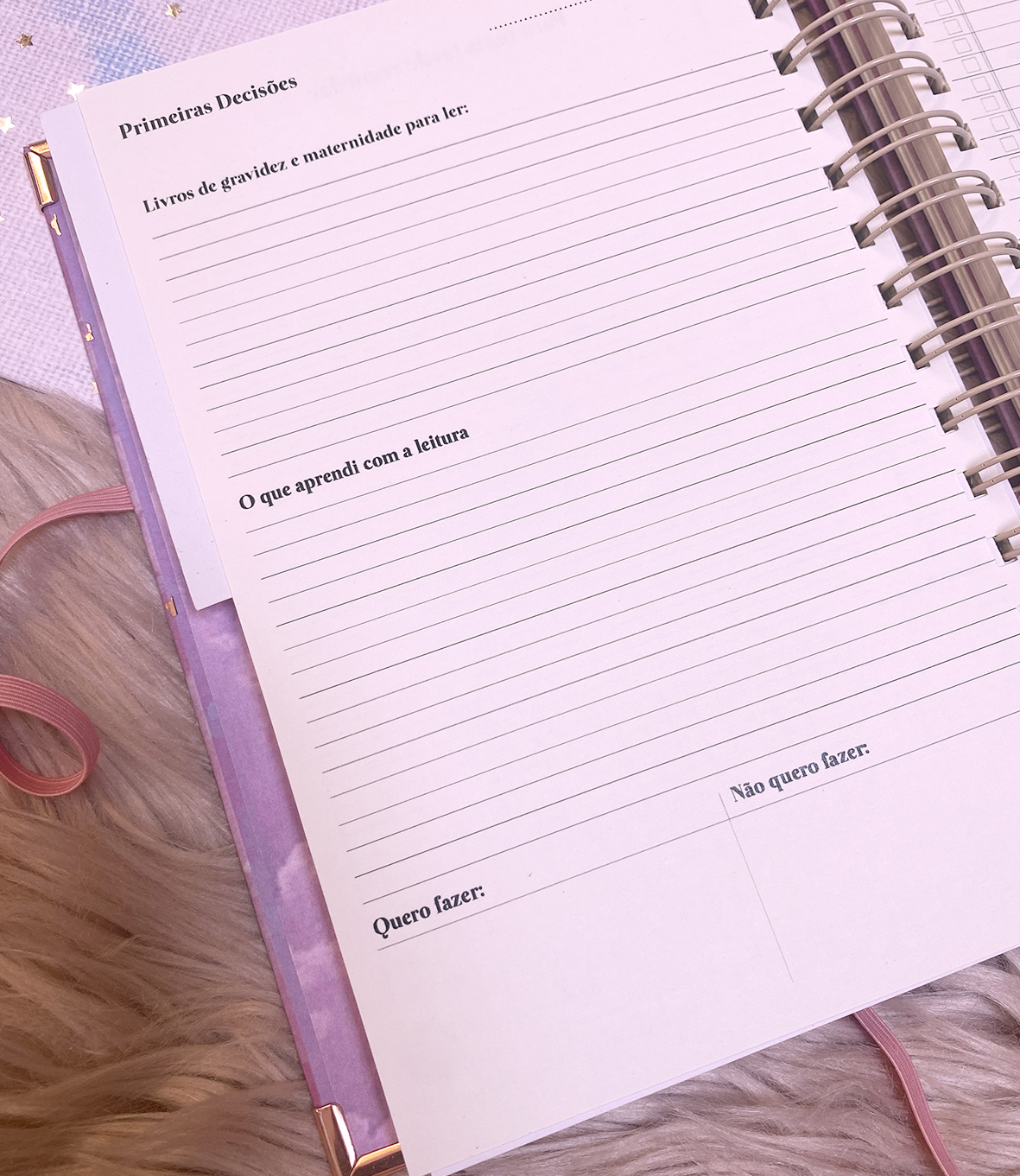 Página de caderno em espiral com texto impresso em português e linhas para escrita, sobre tapete felpudo