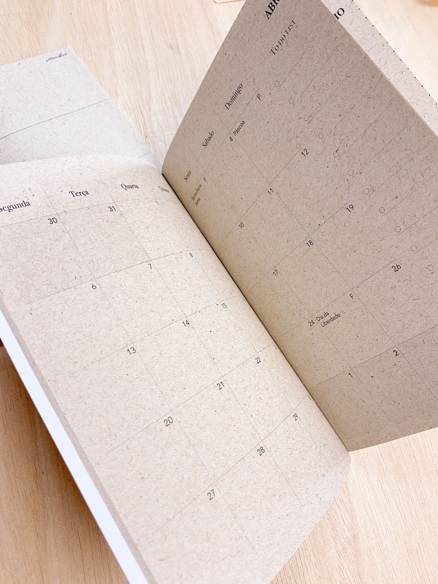 Calendário mensal em papel castanho claro com dias da semana em português