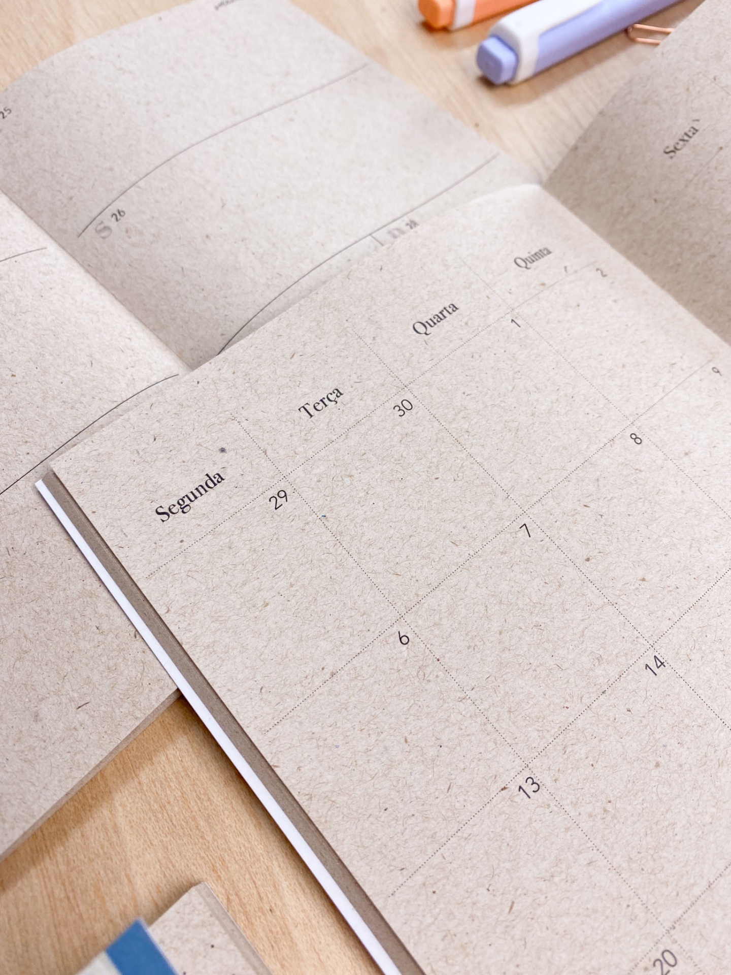 Agenda semanal em papel reciclado castanho com dias da semana e datas impressas em preto