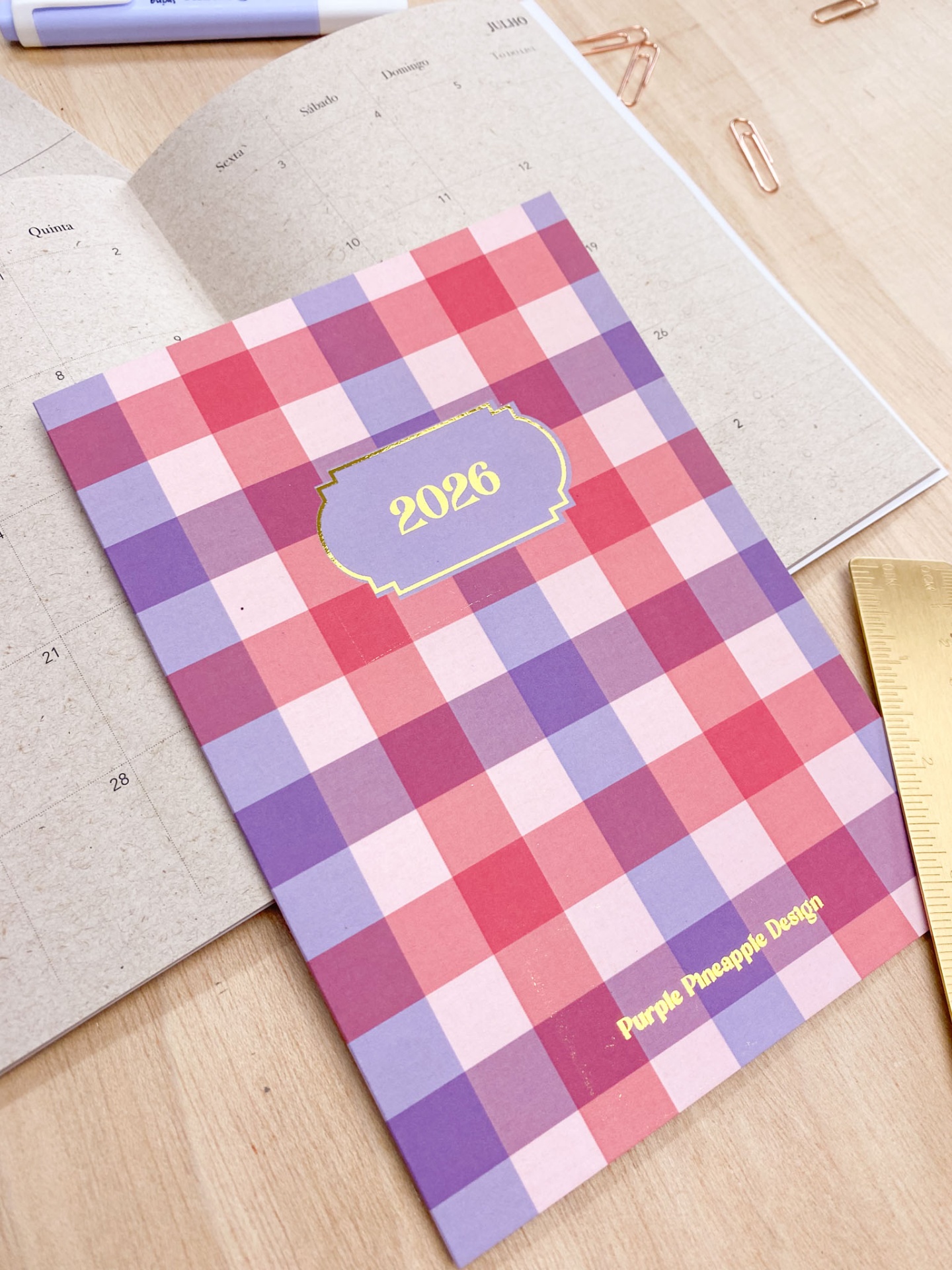Agenda quadriculada 2026 com texto Purple Pineapple Design sobre calendário