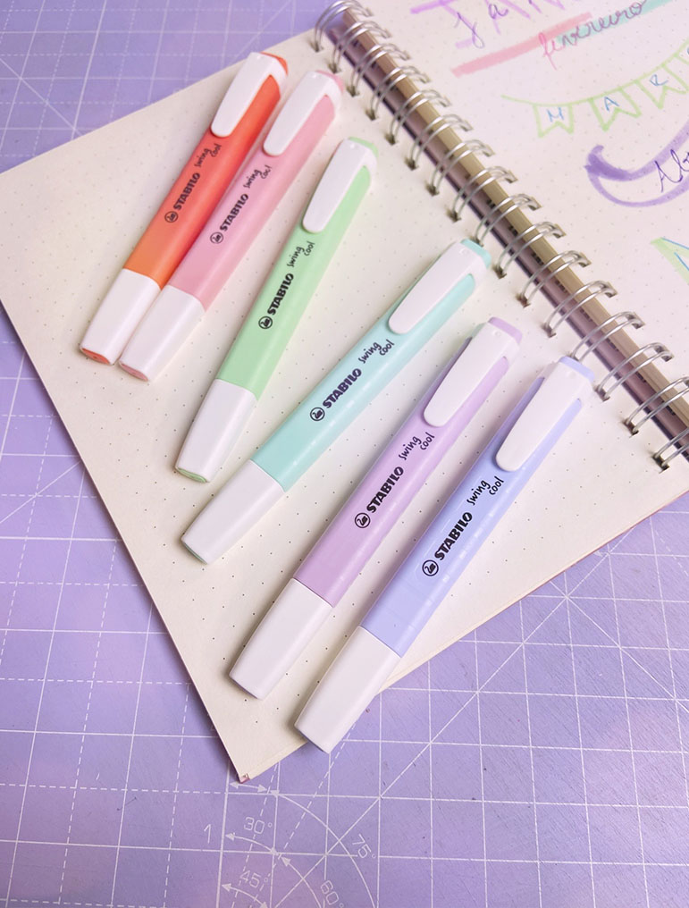 Seis marcadores Stabilo Boss Mini em cores pastel sobre caderneta de argolas com folhas pontilhadas