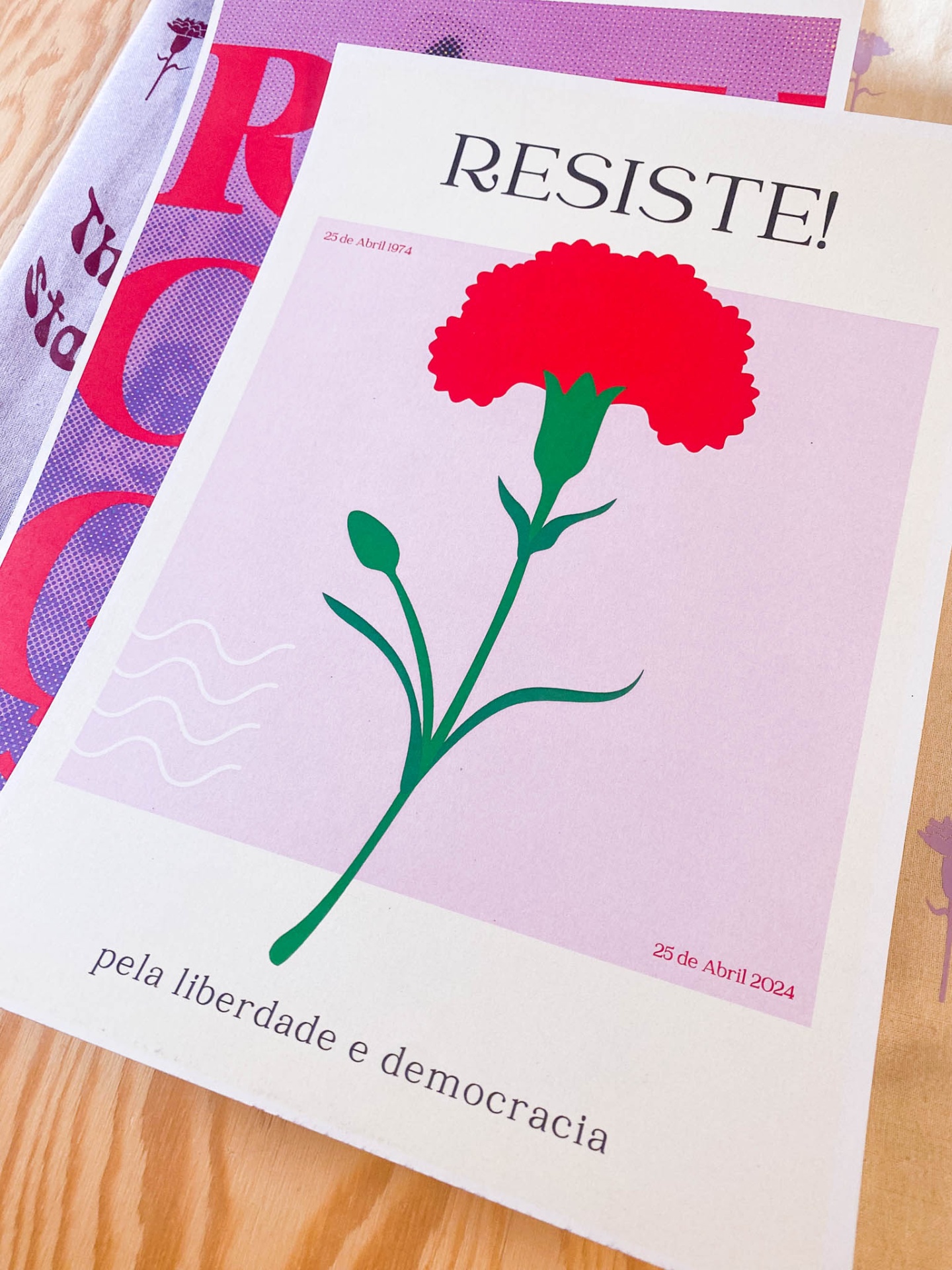 Cartaz com cravo vermelho e texto RESISTE!, 25 de Abril 2024,  pela liberdade e democracia