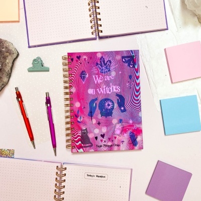 Agenda espiral colorida com ilustrações e vários cadernos e notas adesivas ao redor