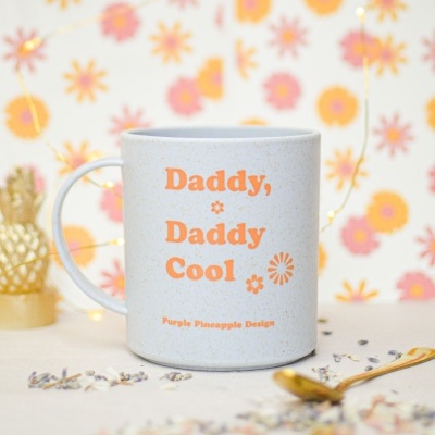 Caneca branca com texto laranja e decoração floral em fundo floral colorido