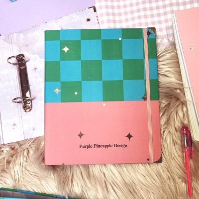 Caderno rosa e verde com padrão xadrez e texto Purple Pineapple Design
