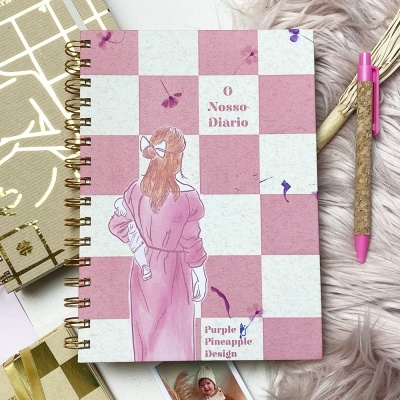 Caderno de capa xadrez rosa e branco com ilustração de mulher e textos O Nosso Diário e Purple Pineapple Design.