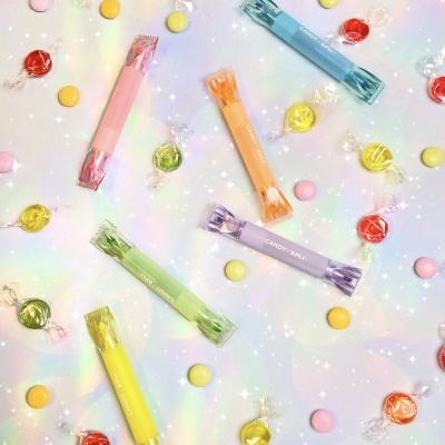 Balas coloridas e rebuçados em embalagem pastel sobre fundo brilhante