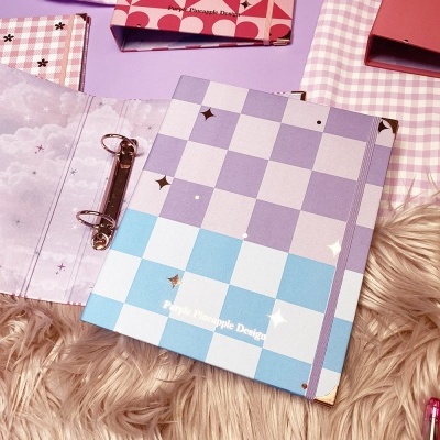 Cadernos e agendas com capas quadriculadas em tons pastel, com texto 'Purple Pineapple Designs'