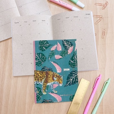 agenda 2026 com capa de onça e folhas, marcadores, canetas, régua dourada e clipes