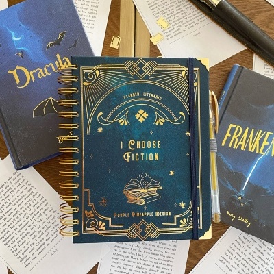 Cadernos e livros sobre páginas impressas com capas e textos em tons azuis e dourados