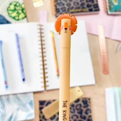 Caneta bege claro com figura de leão laranja na tampa e texto 'THE KING'