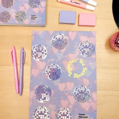 Material de escritório com decoração azul e rosa com acessórios coloridos sobre mesa de madeira