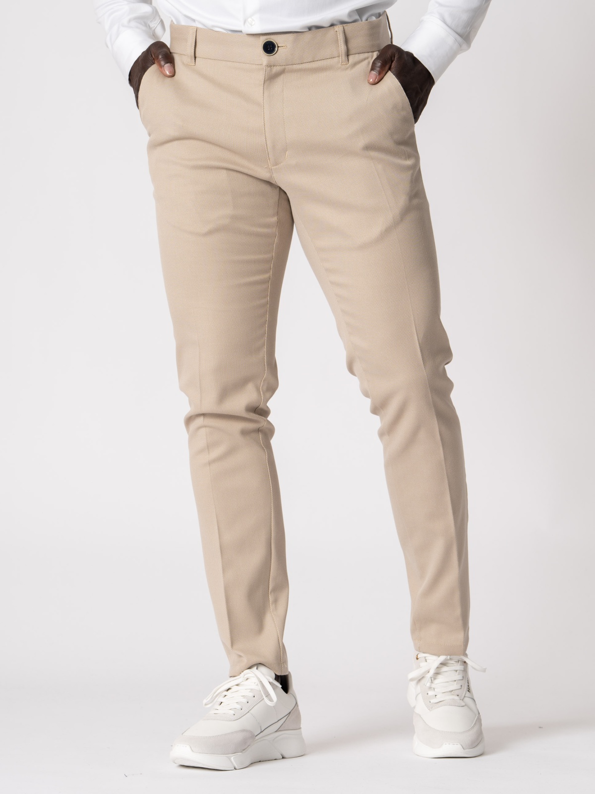 Calça SMK Golden Wear Calças bege com camisa branca e sapatos desportivos brancos