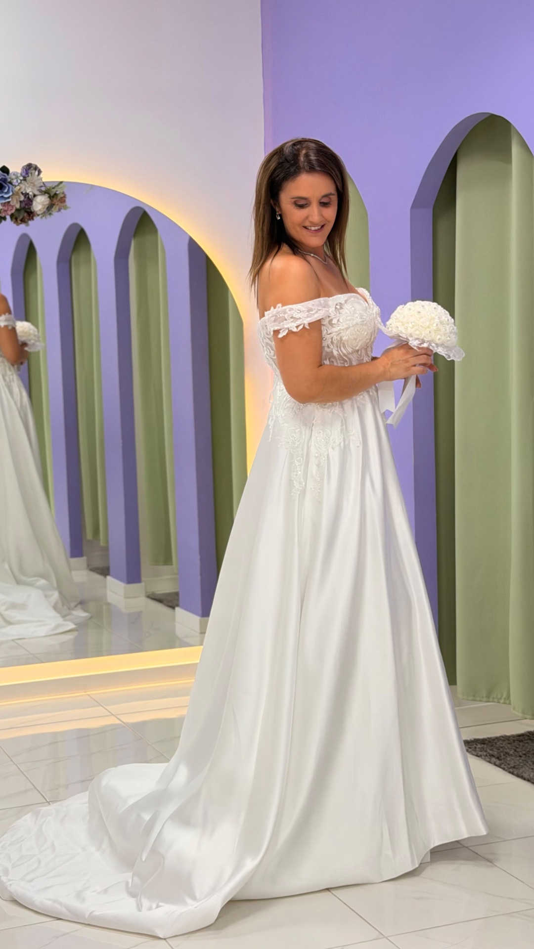 Vestido Amour Glamour Mulher com vestido de noiva branco em ambiente com espelhos e paredes lilás