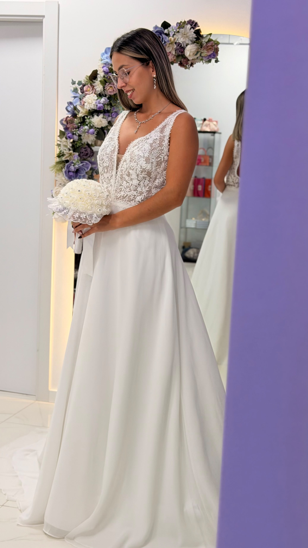Vestido Miriam Noiva Mulher com vestido de noiva branco e buquê, arco floral ao fundo