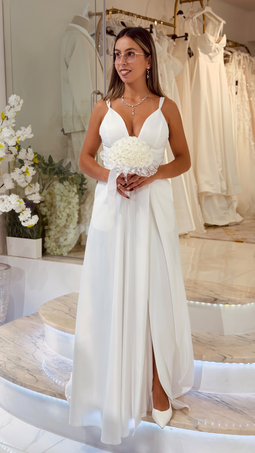 Vestido Muse Noiva Vestido de noiva branco com alças largas e decote em V com bouquet de flores brancas