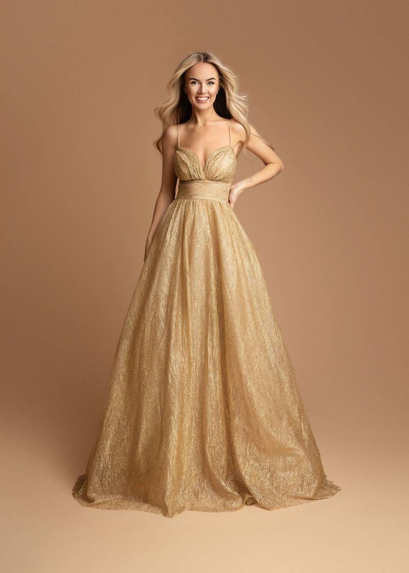 Vestido Alice Vestido longo dourado com alças finas e saia ampla, textura ligeiramente enrugada.